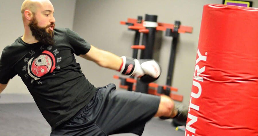 Coach Forrest practicing a kick on a heavy bag